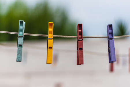 4 multi-colored clothespins in a ropeの写真素材
