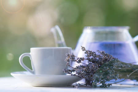 bouquet of dried lavender, lavender tea in a teapot and a cup. on a natural background. tea partyの写真素材
