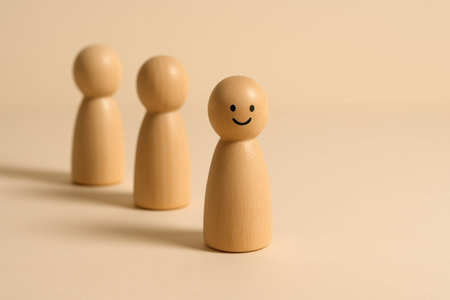 Wooden people standing in a row on a beige background.の素材