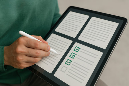 Close-up Of Person's Hand Drawing Checklist On Digital Tabletの素材