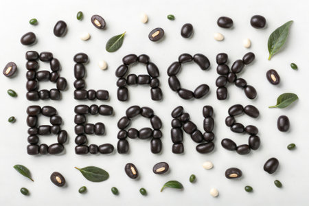 Black bean word made with black beans and green leaves isolated on white backgroundの素材