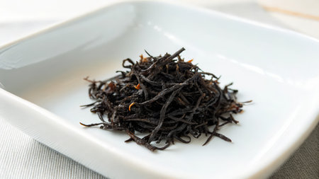 Black tea in a white bowl on a white tablecloth, close-upの素材