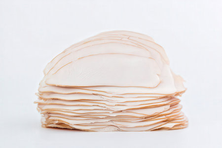 Slices of ham on a white background. Shallow depth of fieldの素材