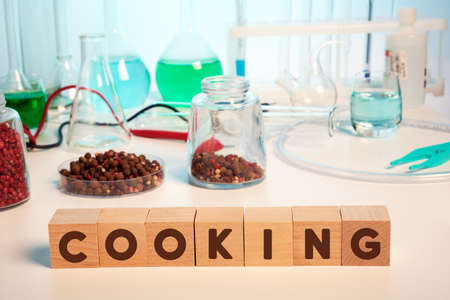 Pepper chemical analysis and cooking text on wooden cubes in lab. Photo of pepper in petri glass...