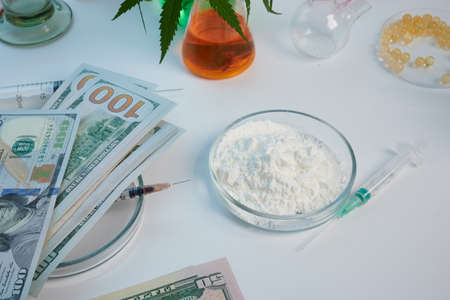 Cocaine flour in glass petri dish and 100 dollar banknotes. Syringe for abuse cocaine inoculation. Dirty money of criminal business. Chemical petri dish glassware with cocaine suspense. Crime profit from drugs and narcotics deal.の写真素材