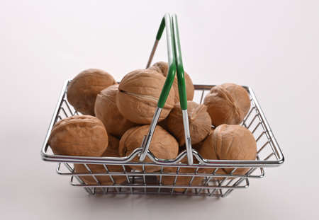 Greek nuts in a small shopping basket. Greek nuts in a little metal cart. A lot of Greek nuts are placed into a small toy shopping metal trolley. The concept of vegan life style. Vegetarian food from Greece.の写真素材
