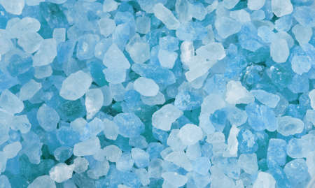 Blue salt crystals as background photo. Closeup blue ice stones lay on a flat surface. Rectangular area of icy crystals. Natural gemstone minerals lie in rectangle background. Photo of salty stones.の写真素材