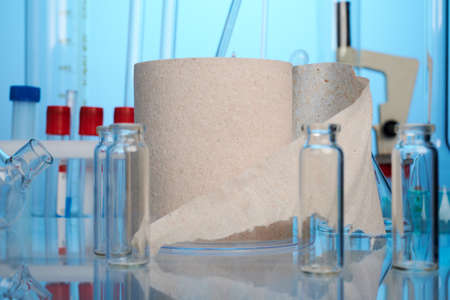 Toilet paper roll on lab desk. Photo with blue gradient background. Paper roll for lavatory hygiene....