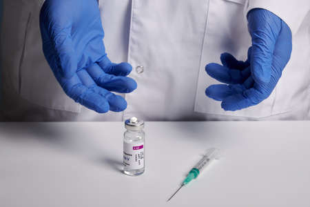 Krasnoyarsk, Russia - February 04, 2022: Doctor presents Sputnik - V vaccine and syringe. Sputnik-V...