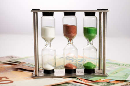 Photo of a sand timer banknotes.