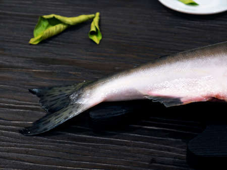 Pink salmon on a cutting on black wooden board, cutting into steaksの写真素材