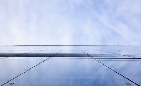 facade of glass and reflection of sky and cloudsの写真素材