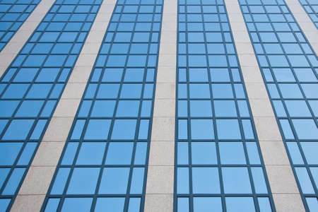 blue sky reflected in grid formed by windowsの写真素材