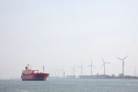 windmills and oil tanker in Nieuwe Waterweg near port of Rotterdam in The Netherlandsの写真素材