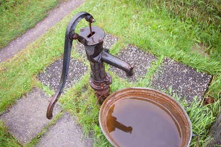 old wet cast iron water pump in gardenの写真素材