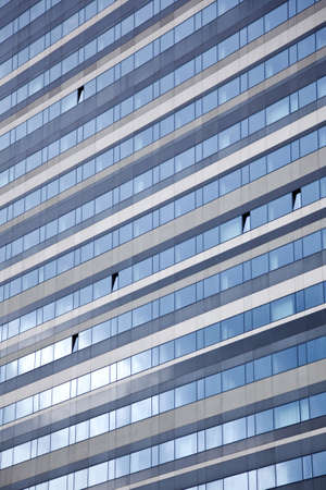 facade of modern building reflecting blue skyの写真素材