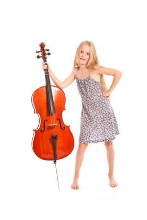 young girl in dress and her cello standing in studio against white backgroundの写真素材