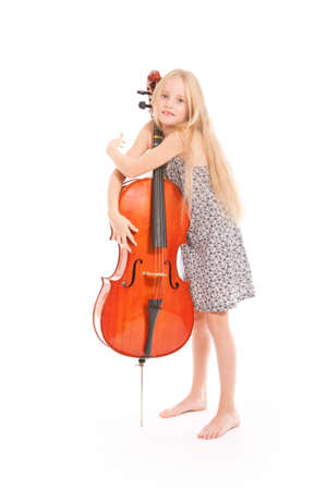 young girl in dress and her cello in studio against white backgroundの写真素材