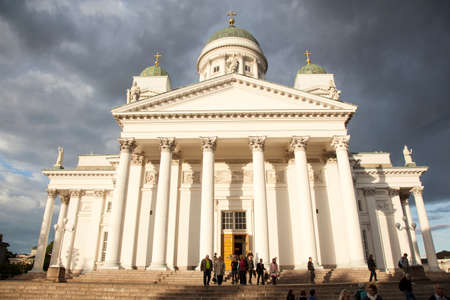 people leaving helsinki cathedral in the evening under threatening skyのeditorial素材