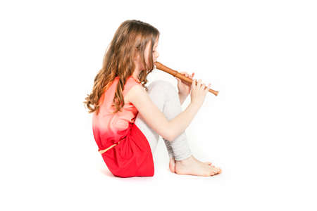 young girl sitting with soprano recorder and white backgroundの写真素材