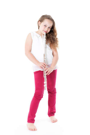 young  girl holding flute standing on the floor of studio with white backgroundの写真素材