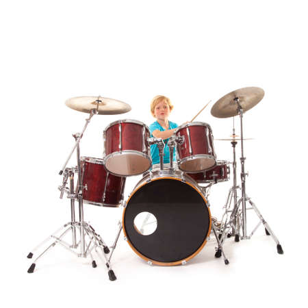 young boy playing drums against white backgroundの写真素材