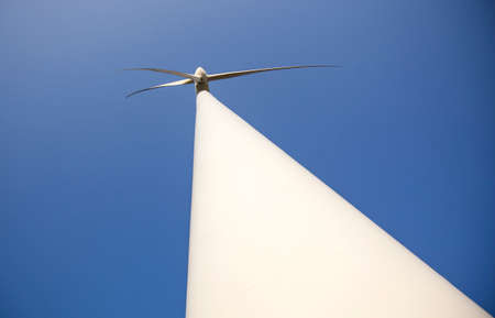 white wind turbine and blue sky seen from low perspectiveの写真素材