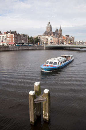 oosterdok in Amsterdam with tourist boat and schreierstoren in the backgroundのeditorial素材
