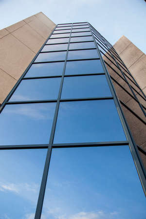facade of office building with very blue sky and cloudsの写真素材