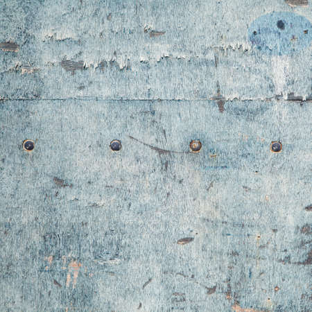 abstract background consisting of weathered board with old blue paint and boltsの写真素材