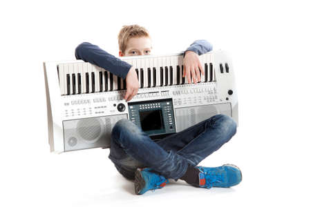 teenage boy with keyboard in studio against white backgroundの写真素材