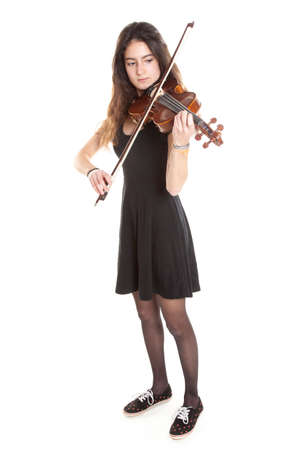 teenage girl plays violin in studio with white backgroundの写真素材