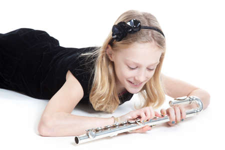 young blond girl holding flute in studio against white backgroundの写真素材