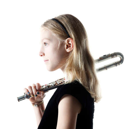 young blond girl sits holding flute on shoulder in studio against white backgroundの写真素材