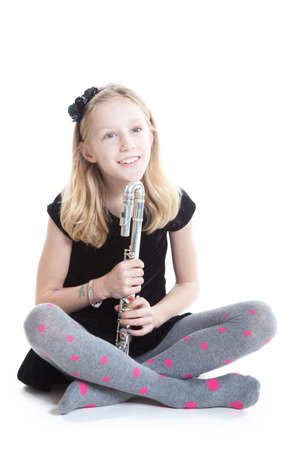 young blond smiling girl holding flute in studio against white backgroundの写真素材