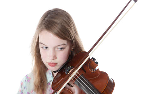 young girl in studio against white background plays the violinの写真素材