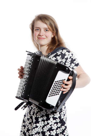 teenage girl stands in studio with accordion against white backgroundの写真素材