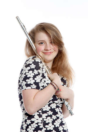 teenage girl in dress holds flute in studio against white backgroundの写真素材