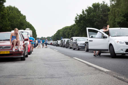 girl sits on car during traffic jam on motorway in germanyのeditorial素材