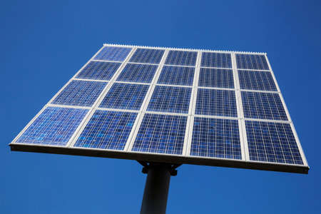 closeup of a chess board pattern of solar panels close together and blue skyの写真素材