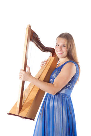 young smiling caucasian woman stands with small harp in studio against white background