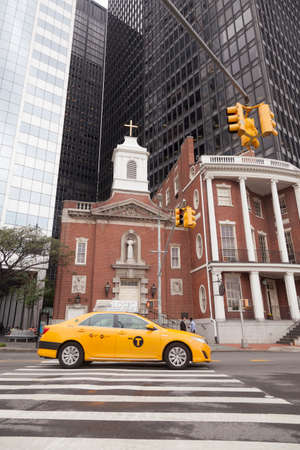 church of our lady of the rosary in downtown manhattan with skyscrapers in the background and yellow cabのeditorial素材