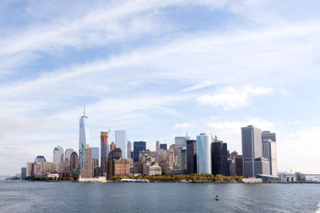 lower manhattan skyline above waterfront  with blue sky and clouds seen from the southの写真素材