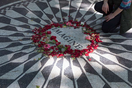 New York City, 14 september 2015: man pays tribute to john lennon on mosaic memorial in central park new york cityのeditorial素材