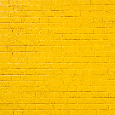 square part of bright yellow painted brick wallの写真素材