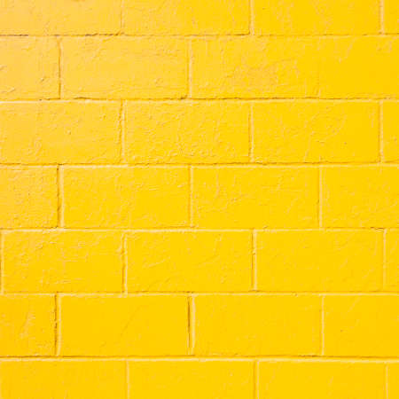 square part of bright yellow painted brick block wallの写真素材