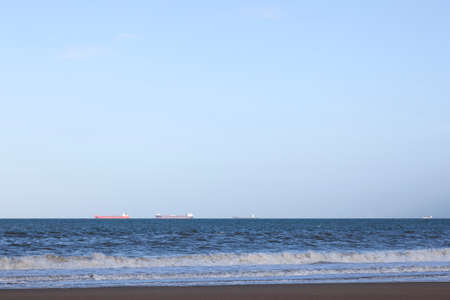 ships wait on north sea for rotterdam harbor in the netherlandsの写真素材