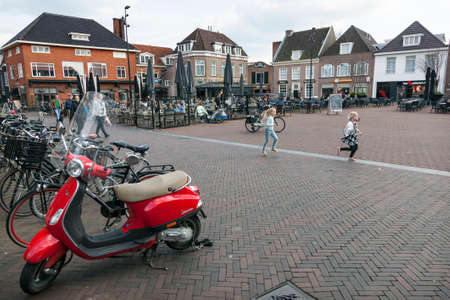 people enjoy nice spring day on the market of dutch town harderwijk while children run aroundのeditorial素材