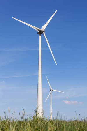 wind turbines in the dutch province of flevoland with grass and blue sky in sunny wheather.の写真素材