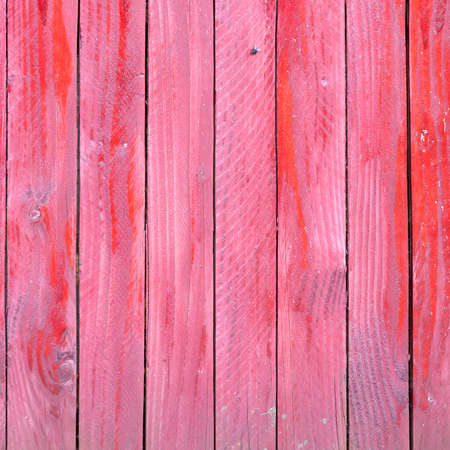 vertical planks of faded red painted worn planks on square piece of fence or doorの写真素材